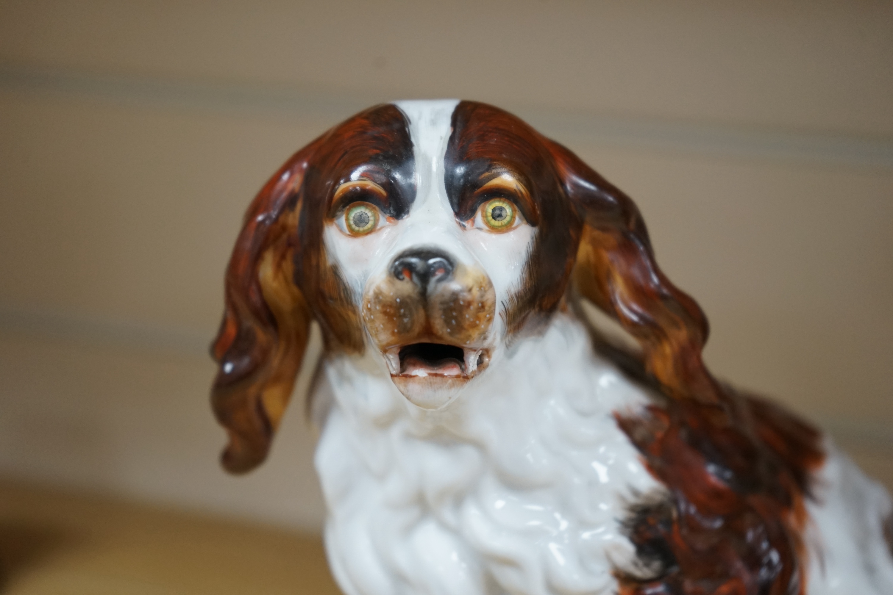 A Sitzendorf porcelain model of seated Spaniel, 21cm. Condition - repaired paw